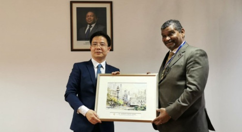 O Secretário-Geral Adjunto Dr. Ding Tian oferece lembrança ao Dr. Ragendra de Sousa, Ministro da Indústria e Comércio de Moçambique