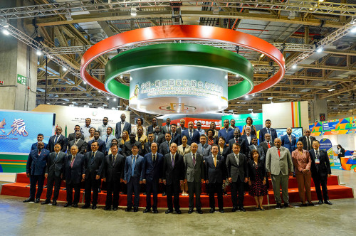 Fotografia de grupo dos convidados em frente da Exposição sobre a Cooperação Económica e Comercial entre a China e os Países de Língua Portuguesa